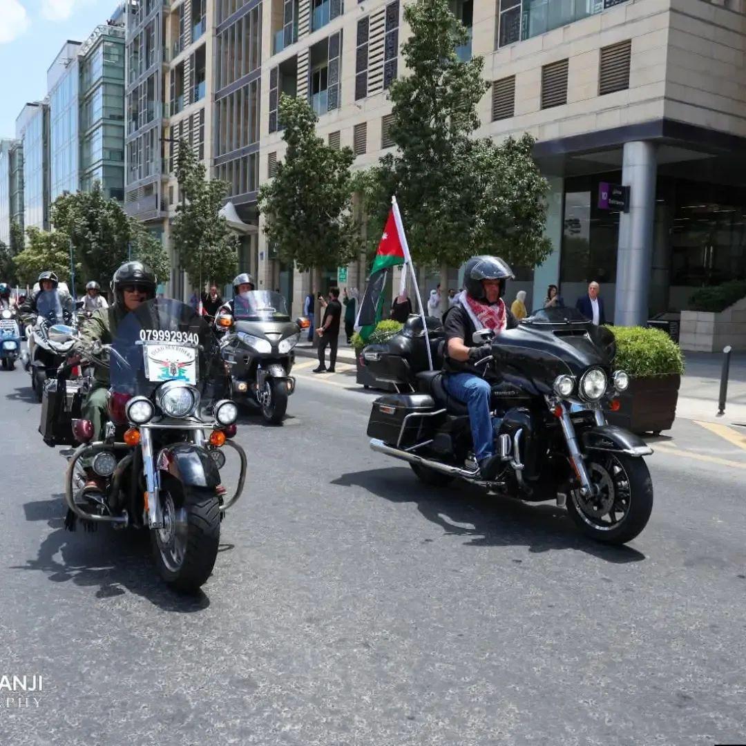 دراجتان من القافلة تسيران في بوليفارد العبدلي بين المارّة، وعلم أردني مرفوع على إحداهما