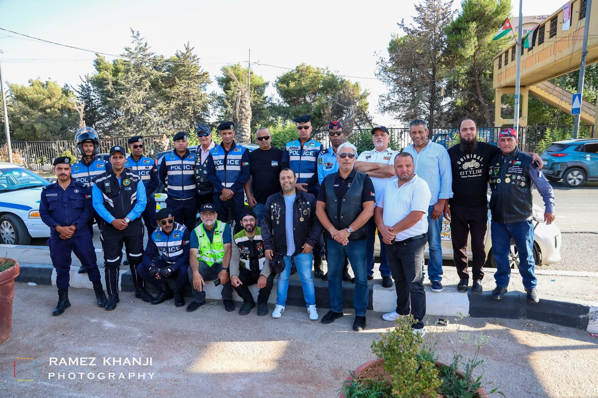 صورة جماعية لأعضاء النادي مع ضباط الأمن العام الذين واكبوا المسيرة، وسيارة الدورية خلفهم